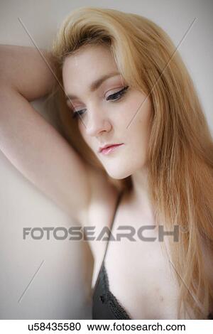 Stock Image - Woman leaning against wall. Fotosearch
