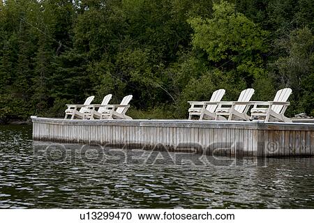 Adirondack chairs on a dock, Kenora, Lake of The Woods, Ontario, Canada View Large Photo Image Stock Image - Adirondack chairs on a dock, Kenora, Lake of The Woods, Ontario, Canada. Fotosearch