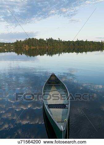 Stock Image - Boat moored in a lake, Lake of The Woods, Ontario, Canada. Fotosearch