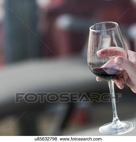 Stock Photo - Close-up of a person holding a glass of wine, Lake of The Woods, Ontario, Canada. Fotosearch
