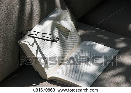Stock Image - Close-up of eyeglasses on a book, Lake of The Woods, Ontario, Canada. Fotosearch