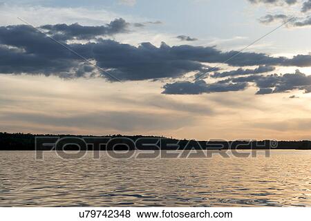 Stock Photo - Clouds over a lake at dusk, Lake of The Woods, Ontario, Canada. Fotosearch