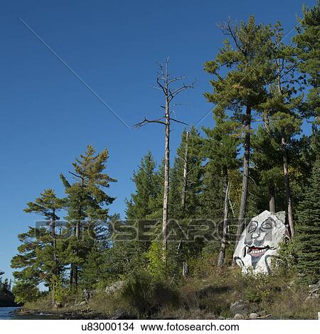 Picture - Face Painted on a Rock at the lakeside, Lake of The Woods, Ontario, Canada. Fotosearch