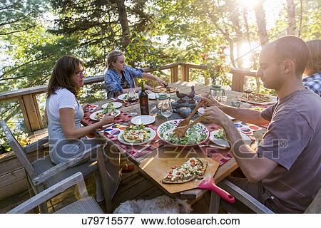 Family having meal on a deck, Lake of The Woods, Ontario, Canada View Large Photo Image Stock Photo - Family having meal on a deck, Lake of The Woods, Ontario, Canada. Fotosearch
