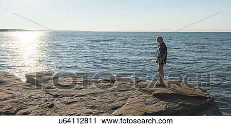 Girl on rocky coastline at Atlantic Ocean, Cavendish Beach, Green Gables, Prince Edward Island, Canada View Large Photo Image Stock Image - Girl on rocky coastline at Atlantic Ocean, Cavendish Beach, Green Gables, Prince Edward Island, Canada. Fotosearch
