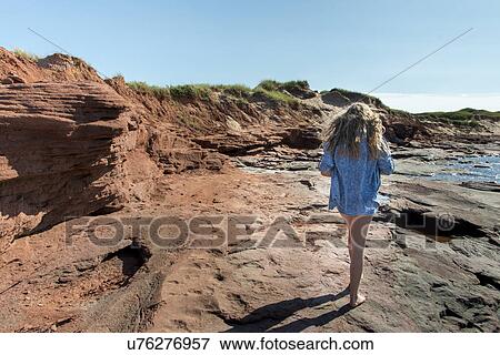Stock Photo - Girl walking along coastline, Cavendish Beach, Green Gables, Prince Edward Island, Canada. Fotosearch
