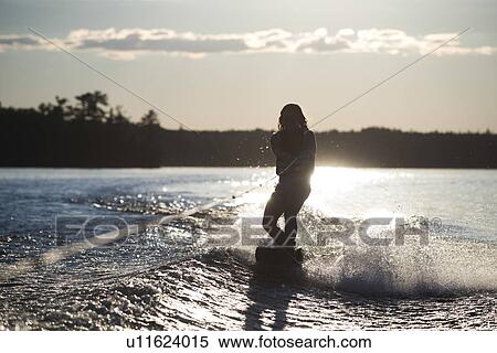 Girl waterskiing with the glow of sunlight behind her, Lake of The Woods, Ontario, Canada View Large Photo Image Stock Photography - Girl waterskiing with the glow of sunlight behind her, Lake of The Woods, Ontario, Canada. Fotosearch