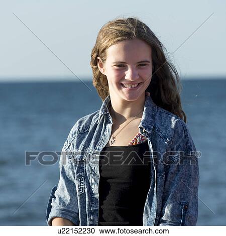 Stock Image - Girl with Atlantic Ocean in background, Cavendish Beach, Green Gables, Prince Edward Island, Canada. Fotosearch