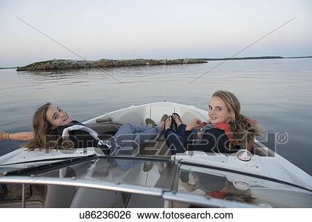 Stock Photograph - Girls relaxing on a boat, Lake of The Woods, Kenora, Lake of The Woods, Ontario, Canada. Fotosearch