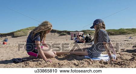 Girls sitting on the beach, Cavendish Beach, Green Gables, Prince Edward Island, Canada View Large Photo Image Stock Image - Girls sitting on the beach, Cavendish Beach, Green Gables, Prince Edward Island, Canada. Fotosearch