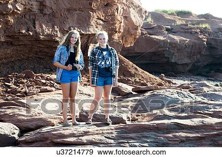Girls standing on rocky coastline, Cavendish Beach, Green Gables, Prince Edward Island, Canada View Large Photo Image Stock Photo - Girls standing on rocky coastline, Cavendish Beach, Green Gables, Prince Edward Island, Canada. Fotosearch