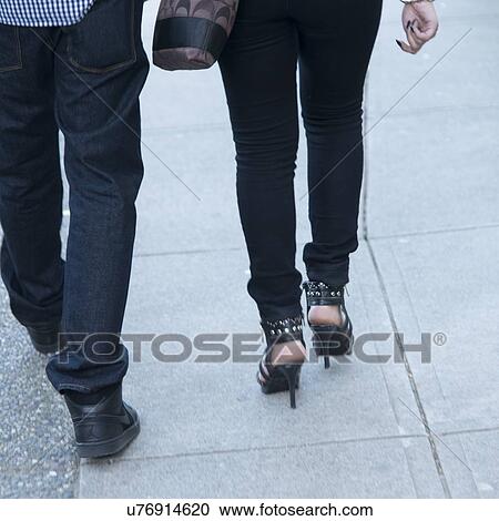 Stock Image - Low section view of a couple walking on street, Vancouver, British Columbia, Canada. Fotosearch