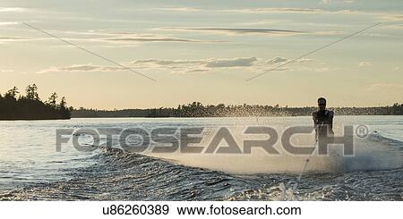 Stock Photo - Man waterskiing in a lake, Lake of The Woods, Ontario, Canada. Fotosearch