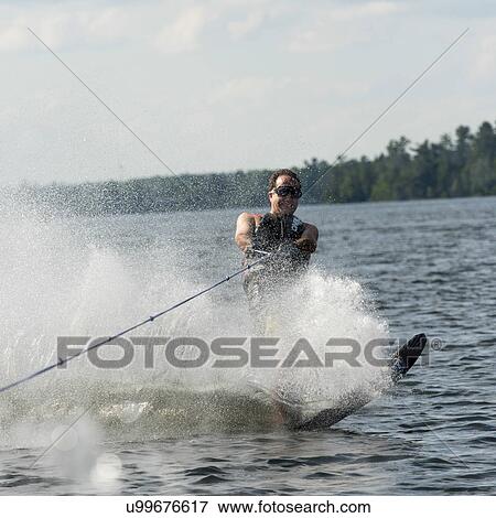Stock Photo - Man waterskiing in a lake, Lake of The Woods, Ontario, Canada. Fotosearch