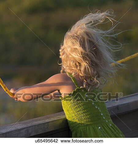 Stock Image - Rear view of a girl with hair blowing in the wind, North Rustico, Prince Edward Island, Canada. Fotosearch