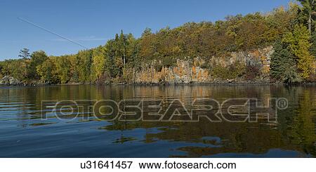 Reflection of trees along coastline, Kenora, Lake of The Woods, Ontario, Canada View Large Photo Image Stock Photo - Reflection of trees along coastline, Kenora, Lake of The Woods, Ontario, Canada. Fotosearch
