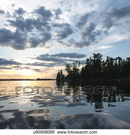 Reflection of tress and clouds on water, Lake of The Woods, Ontario, Canada View Large Photo Image Stock Photo - Reflection of tress and clouds on water, Lake of The Woods, Ontario, Canada. Fotosearch