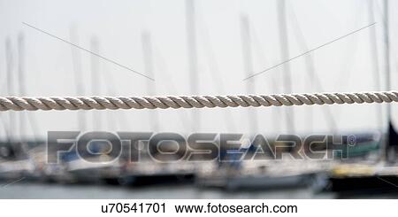 Stock Image - Rope with sailboats at marina in background, Spinnakers Landing, Summerside, Prince Edward Island, Canada. Fotosearch