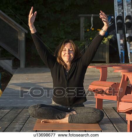 Woman doing yoga on an outdoor deck, Lake of The Woods, Ontario, Canada View Large Photo Image Stock Photo - Woman doing yoga on an outdoor deck, Lake of The Woods, Ontario, Canada. Fotosearch
