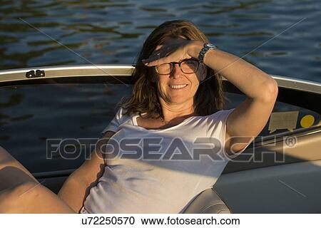 Stock Image - Woman enjoying a boat ride in the sunshine, Lake of The Woods, Ontario, Canada. Fotosearch
