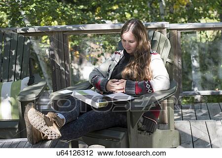 Stock Image - Woman reading a book, Lake of The Woods, Ontario, Canada. Fotosearch