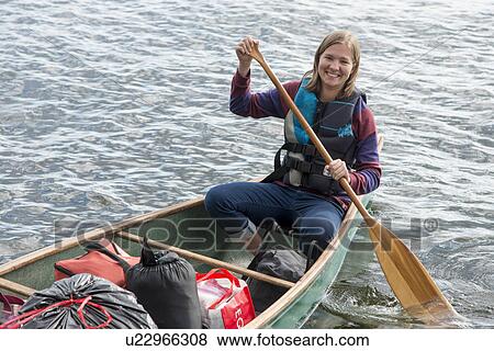 Woman rowing a boat in a lake, Lake of The Woods, Ontario, Canada View Large Photo Image Stock Photo - Woman rowing a boat in a lake, Lake of The Woods, Ontario, Canada. Fotosearch