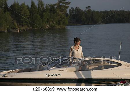 Woman standing on a boat, Lake of The Woods, Ontario, Canada View Large Photo Image Stock Photo - Woman standing on a boat, Lake of The Woods, Ontario, Canada. Fotosearch