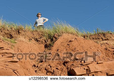 Woman standing on top of cliff, Green Gables, Cavendish, Prince Edward Island, Canada View Large Photo Image Stock Photograph - Woman standing on top of cliff, Green Gables, Cavendish, Prince Edward Island, Canada. Fotosearch