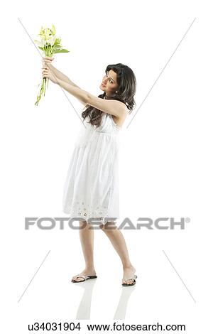 Picture - A beautiful woman holding flowers . Fotosearch