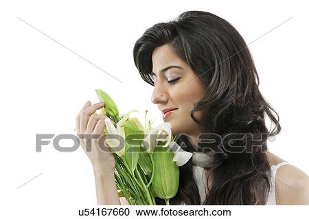 Stock Image - A beautiful woman holding flowers . Fotosearch