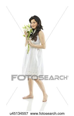 Stock Photo - A beautiful woman holding flowers . Fotosearch
