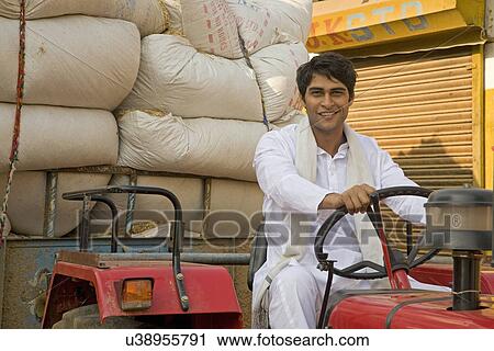 Stock Image - A farmer on his tractor . Fotosearch