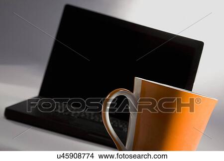 Picture - A laptop and a cup . Fotosearch