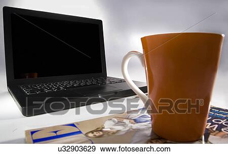 A laptop and a cup View Large Photo Image Stock Photo - A laptop and a cup . Fotosearch