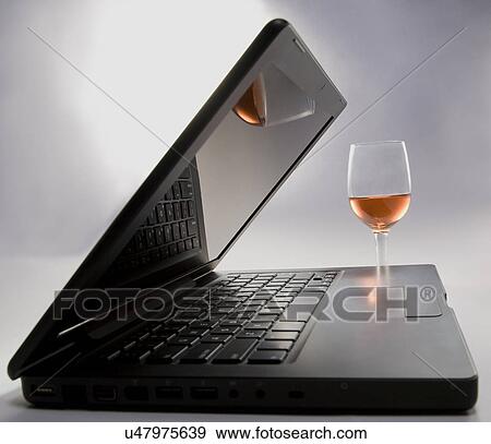 Stock Photo - A laptop and a glass . Fotosearch