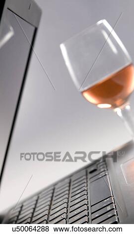 Stock Photo - A laptop and a glass . Fotosearch