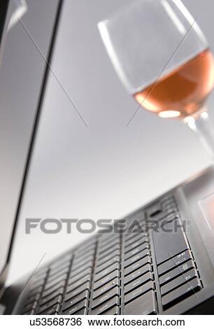 Stock Photograph - A laptop and a glass . Fotosearch