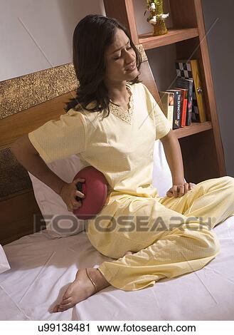 A woman applying a hot water bag View Large Photo Image Stock Image - A woman applying a hot water bag . Fotosearch