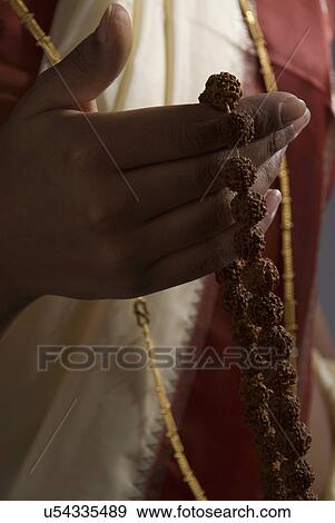 Stock Photo - A woman holding a rosary . Fotosearch