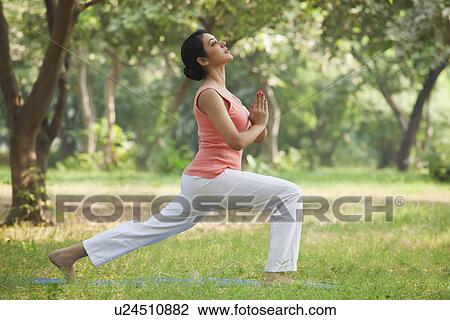 Stock Image - Active young woman practicing yoga . Fotosearch