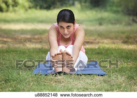 An attractive woman stretching in lawn View Large Photo Image Stock Photo - An attractive woman stretching in lawn . Fotosearch