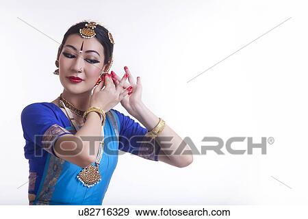 Stock Photo - Beautiful Bharat Natyam dancer performing over white background. Fotosearch