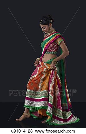 Stock Photo - Beautiful bride lifting her saree. Fotosearch