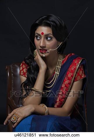 Stock Image - Beautiful bride with jewelery sitting. Fotosearch