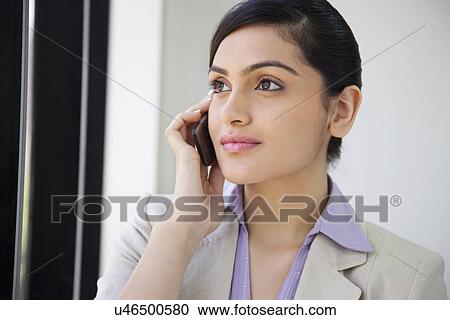 Beautiful businesswoman using mobile phone in office View Large Photo Image Stock Image - Beautiful businesswoman using mobile phone in office . Fotosearch