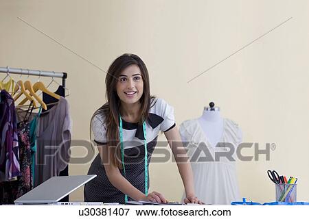 Beautiful female fashion designer working in studio View Large Photo Image Stock Photo - Beautiful female fashion designer working in studio . Fotosearch