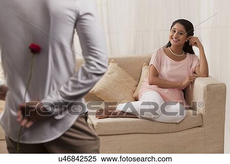 Beautiful Indian woman looking at man while relaxing on sofa View Large Photo Image Stock Photography - Beautiful Indian woman looking at man while relaxing on sofa . Fotosearch