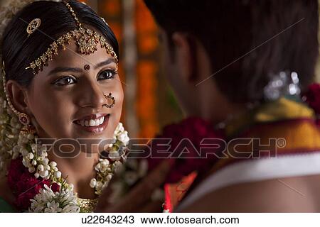 Beautiful smiling bride looking at groom during wedding ceremony View Large Photo Image Stock Image - Beautiful smiling bride looking at groom during wedding ceremony . Fotosearch