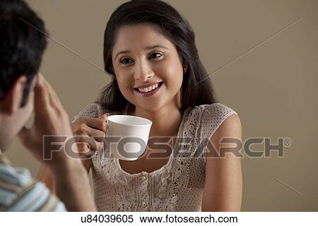 Stock Photography - Beautiful woman having a cup of coffee with man . Fotosearch
