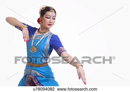 Stock Image - Beautiful woman performing Indian Bharat Natyam dance on white background. Fotosearch